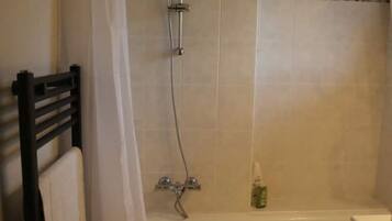 Un baño con ducha, bañera y retrete.