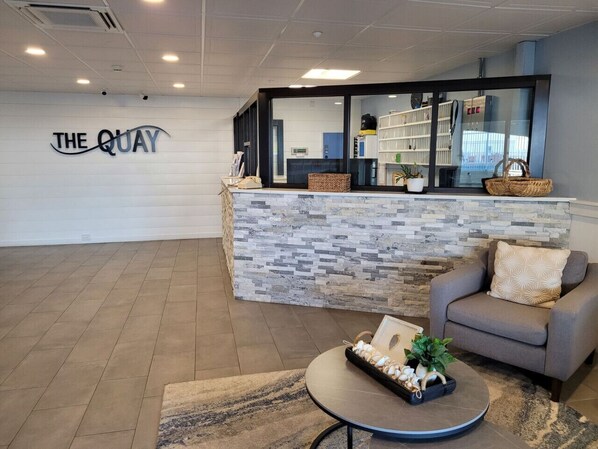 A reception area with a stone counter, a sofa, and a coffee table.