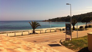 A coastal road with a beach view, a sign for 'Residence U Vane', and a clear sky. - A Rossa Location (Conca)