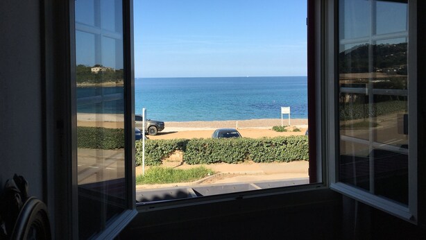 A view from a window overlooking a beach with a clear sky. - A Rossa Location (Conca)