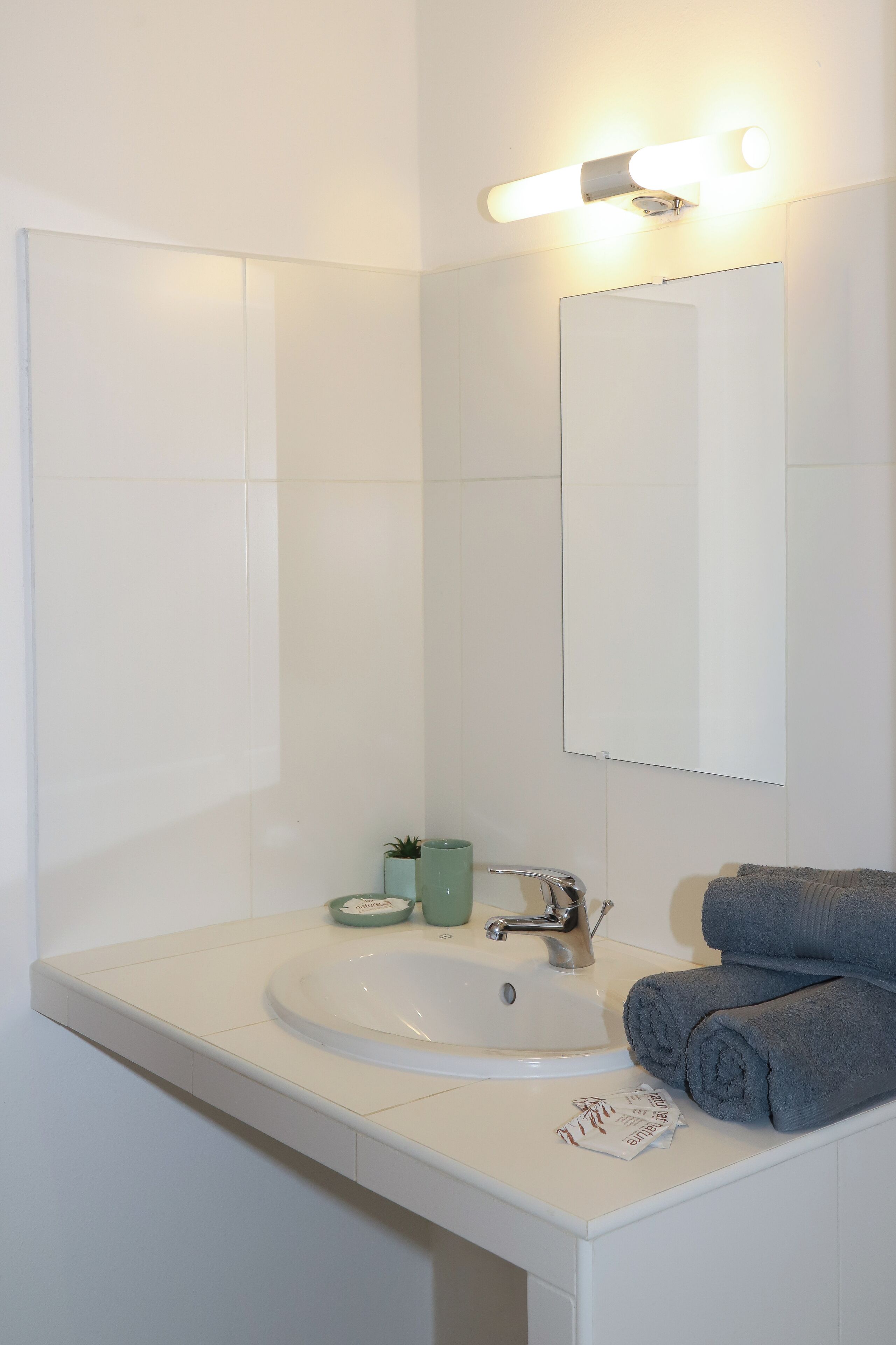 A bathroom with a white sink, a mirror, and a towel rack.