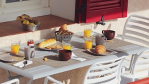 A breakfast table with croissants, bread, and orange juice. - A Rossa Location (Conca)
