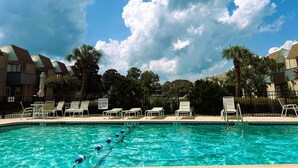 Piscina com espreguiçadeiras e placa indicando área rasa e proibição de mergulho.