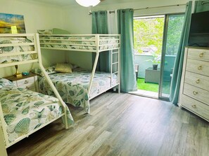 A bedroom with bunk beds, a dresser, and a sliding glass door to a balcony. - Charming home near the beach, downtown and main golf courses. (Myrtle Beach)