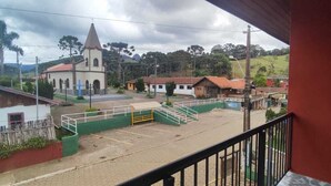 Blick vom Balkon auf eine ländliche Gegend mit Kirche, Spielplatz und Wohnhäusern.