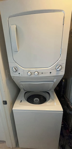 A front view of a white washing machine with control knobs and a front-loading door.