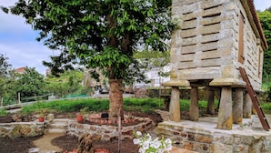 A stone structure with a wooden bench and a potted plant. - House in Mar de Fóra (Fisterra) (Fisterra)