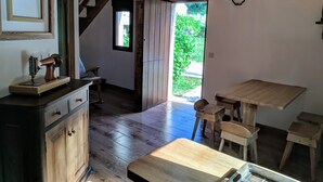 A rustic kitchen with wooden cabinets, a wooden table, and a window with a view of greenery. - House in Mar de Fóra (Fisterra) (Fisterra)