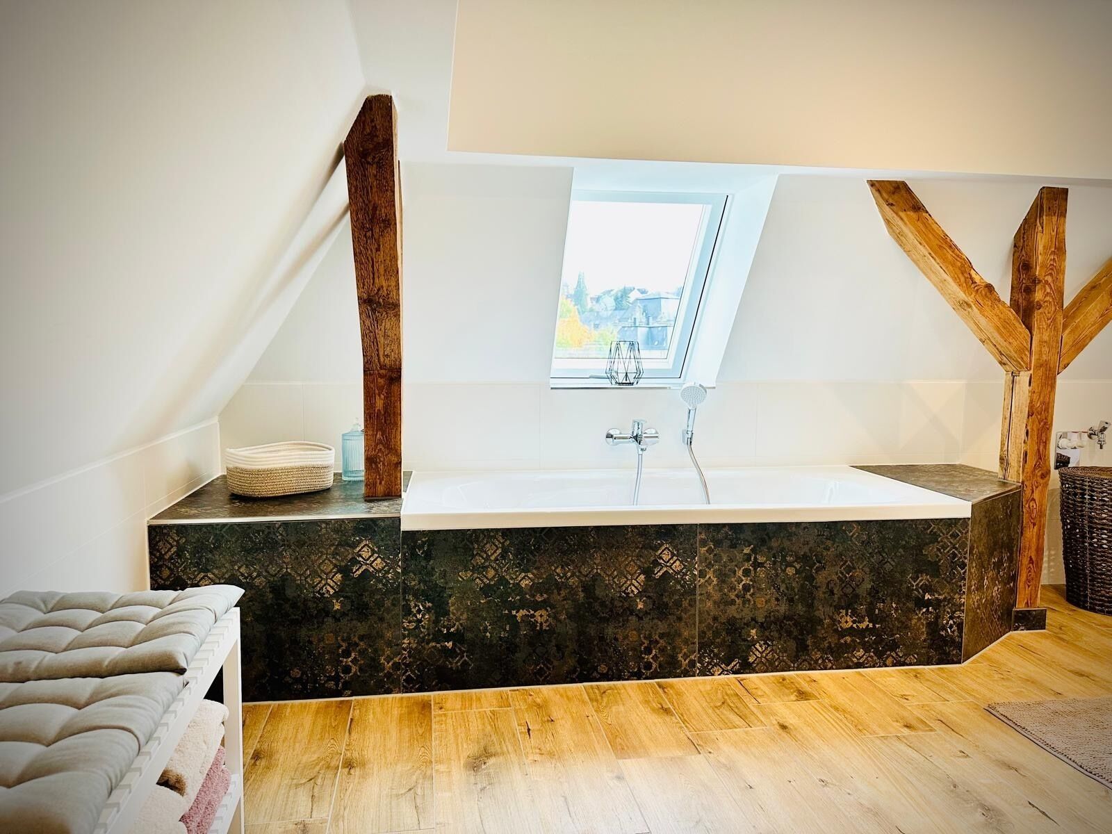 A modern bathroom with a freestanding bathtub, a skylight, and a view of the outdoors.