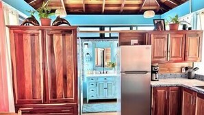 Une cuisine avec des meubles de rangement en bois, un réfrigérateur et un évier.