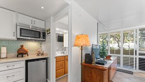 A modern kitchen with white cabinets, a stainless steel microwave, and a dishwasher.