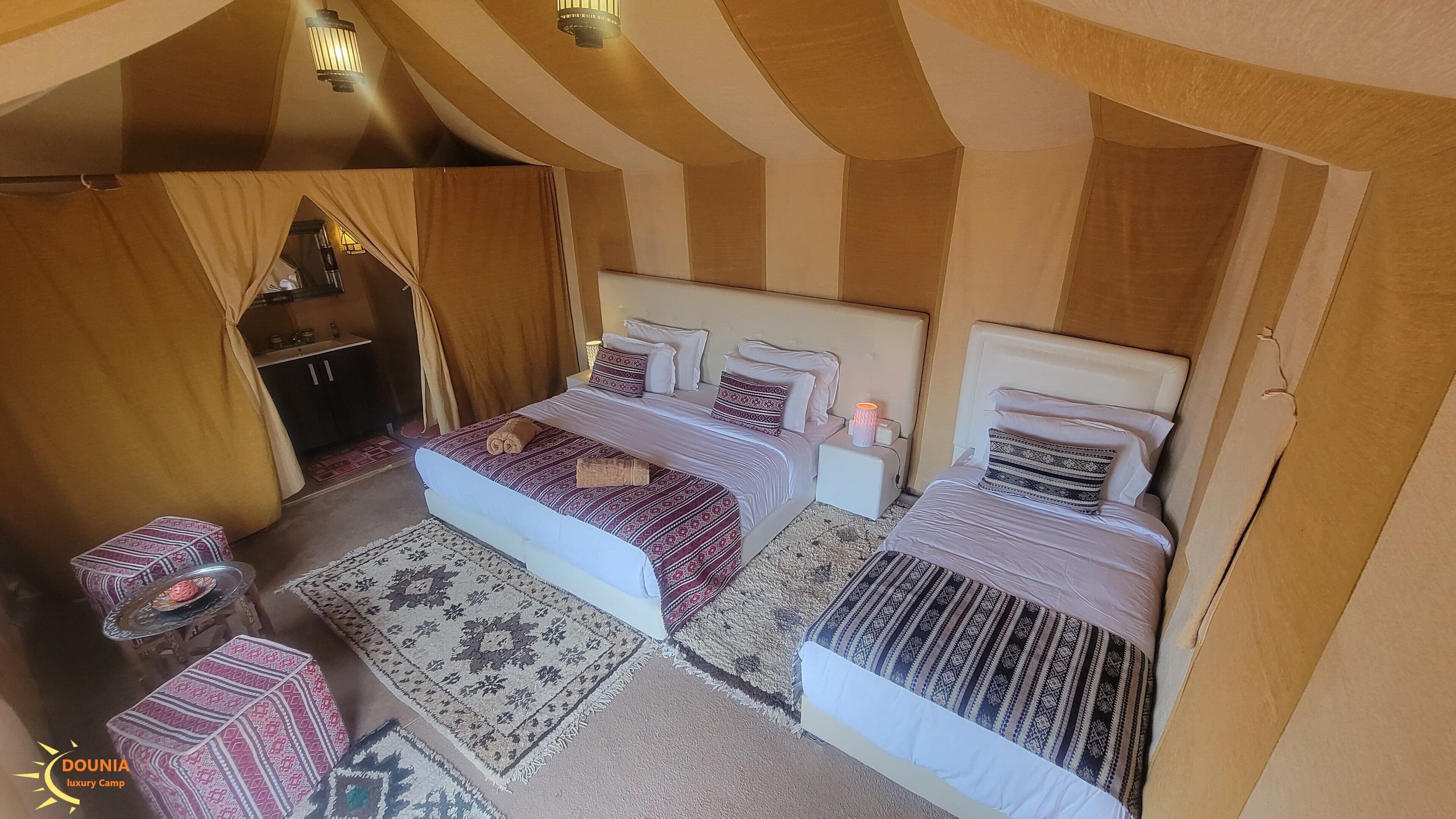 Een gezellige, goed verlichte kamer met twee bedden, een tafeltje en een kast.