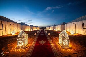 A row of tents with a red carpet and ornate lanterns in the center. - Adrar Luxury Camp (Rissani)