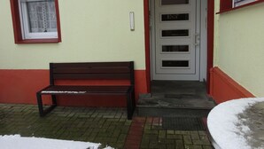 Un banc se trouve devant un bâtiment qui possède une porte et une fenêtre.