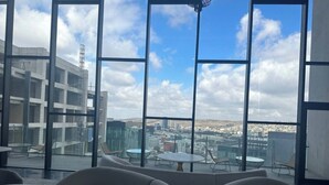 A modern lounge area with large windows offering a city view.