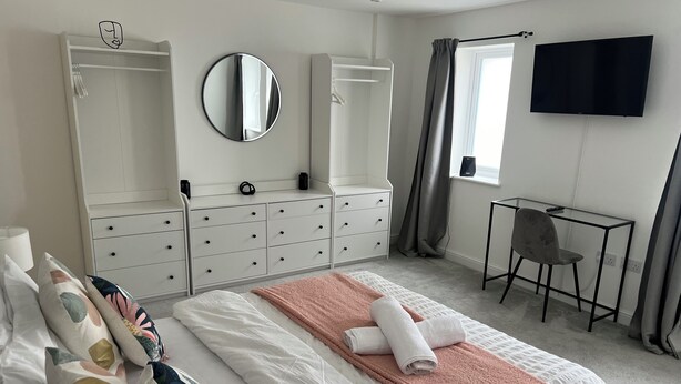 A bedroom with a bed, a desk, a chair, a TV, and a wardrobe. - Charming 2-bedroom apartment in Cardiff city center,  super fast WiFi Netflix (Cardiff)