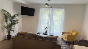 A living room with a sofa, a yellow armchair, a small table, and a potted plant. - Charming 2-bedroom apartment in Cardiff city center,  super fast WiFi Netflix (Cardiff)