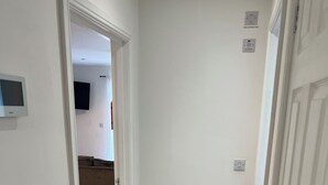 A hallway with wooden flooring, white walls, and a door leading to another room. - Charming 2-bedroom apartment in Cardiff city center,  super fast WiFi Netflix (Cardiff)