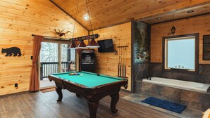 A wooden cabin with a pool table, a bathtub, and a television. - New Build! Charming Wears Valley Cabin! Close to National Park and Attractions! (Sevierville)
