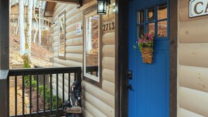 A wooden cabin with a blue door, a welcome sign, and a number sign. - New Build! Charming Wears Valley Cabin! Close to National Park and Attractions! (Sevierville)
