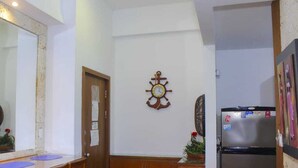 A room with a wooden door, a wall-mounted clock, a refrigerator, and a mirror. - MIRADOR DEL LAGUITO 404 (Cartagena)