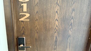 A wooden door with the number 612 and a modern electronic lock.
