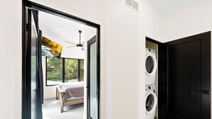 Un dormitorio moderno con un ventanal grande, una cama y un ventilador de techo.