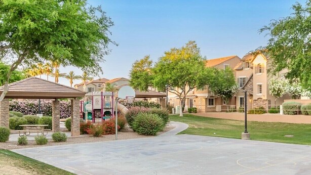 A residential area with a basketball court, picnic tables, and a gazebo.