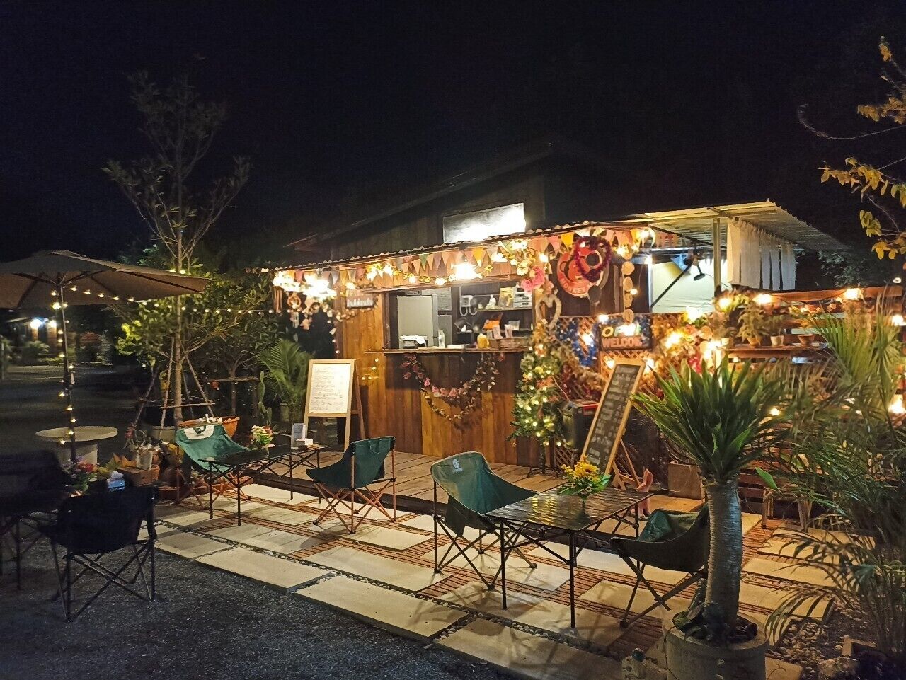 Een terras met tafels en stoelen, een kleine kiosk en een kerstboom.