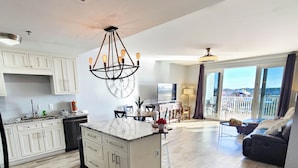 A spacious living area with a large island, a dining area, and a balcony with a view. - Exceptional unit 633!Accessible and  Inviting! Perfect Beach set up! (Panama City Beach)