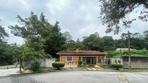 Una propiedad residencial con techo de tejas, patio cercado y entrada pavimentada.