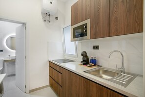 Une cuisine moderne avec des meubles en bois, un évier en acier inoxydable et un four à micro-ondes encastré.