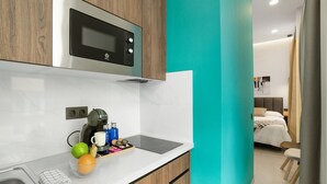 A modern kitchen with a built-in microwave, a coffee machine, and a fruit bowl.