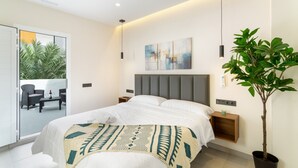 Un dormitorio moderno con cama, mesitas de noche, una planta en maceta y vistas al exterior.