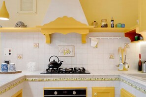 Cafetera o tetera, frigorífico, horno y placa de cocina