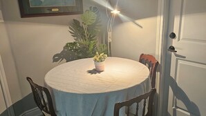A dining area with a round table, four chairs, a potted plant, and a framed picture on the wall. - Cozy 2 Bedrm with separate entrance
 (Kitchener)