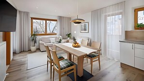 Un comedor moderno con una mesa de madera, sillas y una lámpara colgante.