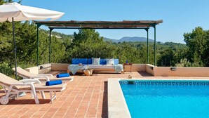A poolside area with lounge chairs, a sofa, and a pergola. - Villa 'Can Roca' with Sea Views, Wi-Fi and Air Conditioning (Illes Balears)