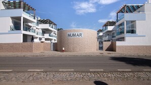 A modern building with a cylindrical central structure labeled 'NUMAR' and multiple balconies. - Apartment 'Numar Residence Aa' with Shared Pool, Wi-Fi and Air Conditioning (Vila Nova de Cacela)