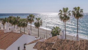 A coastal view with white buildings, palm trees, and a beach. - Apartment 'Flat3-5 Chaparil Beach' with Sea View, Wi-Fi and Air Conditioning (Nerja)