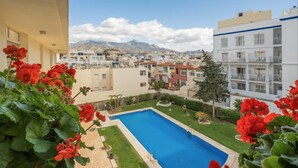 A residential area with a swimming pool, greenery, and buildings with balconies. - Apartment 'Flat3-5 Chaparil Beach' with Sea View, Wi-Fi and Air Conditioning (Nerja)