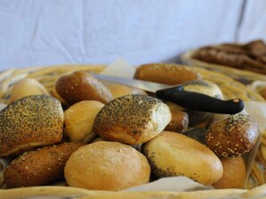 A basket of various types of bread, including poppy-seeded rolls and sesame-seeded rolls. - 3 Person Holiday Home in Nexo (Nexø)