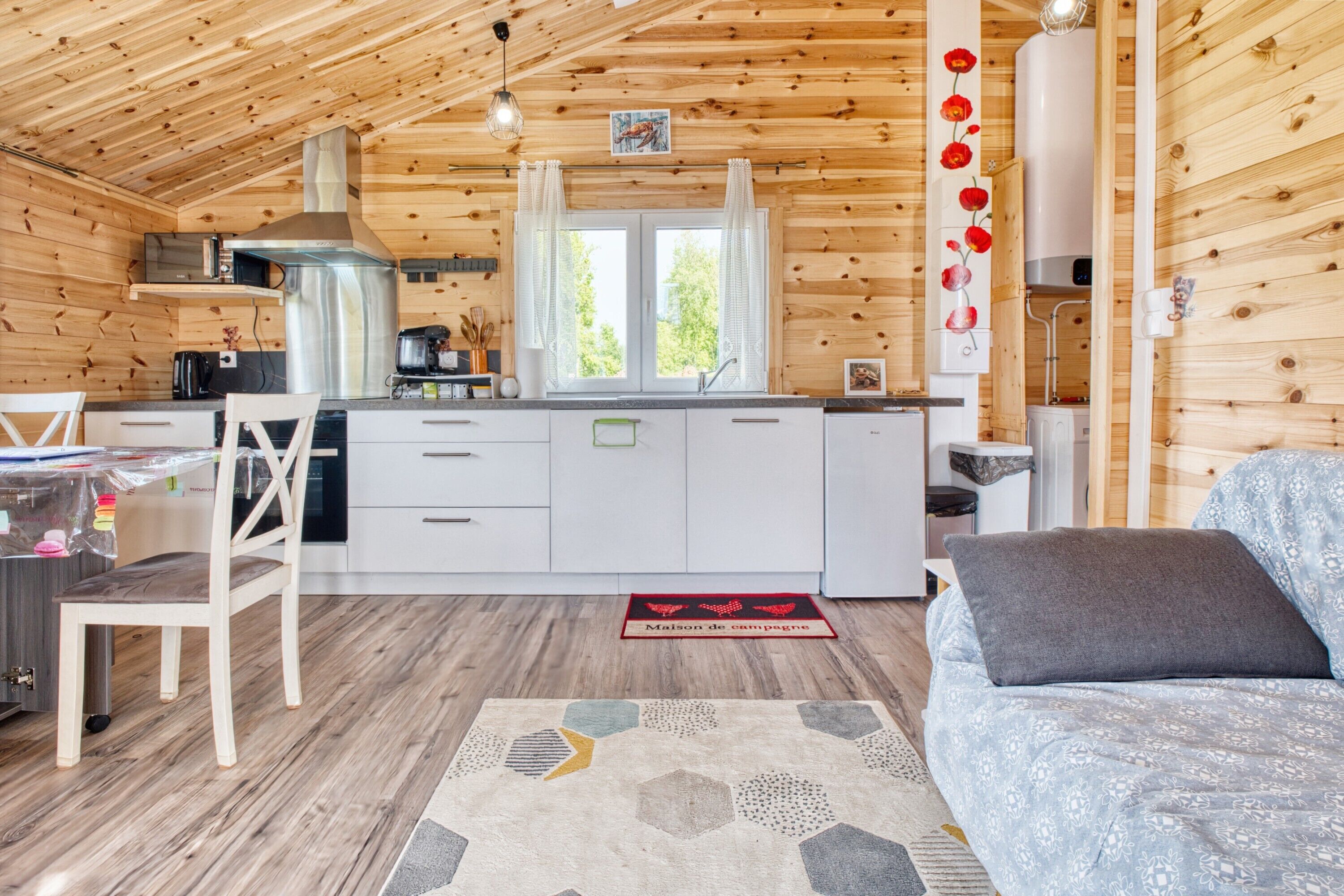 Een houten cabinestijl interieur met keuken, eethoek en zithoek.