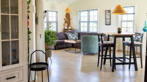 A spacious living area with a sofa, chairs, a dining table, and pendant lights. - Tropical Luxury with Private Pool & Recreational Opportunities! (Willemstad)