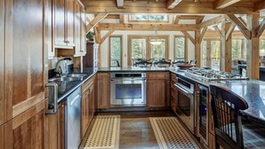A spacious kitchen with wooden cabinets, a stainless steel stove, and a large island with seating.