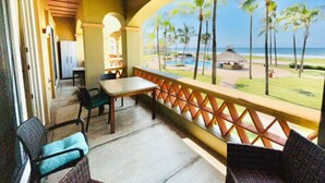 A covered outdoor area with a table and chairs, a view of the beach, and palm trees. - hermoso depa frente al mar by PartnerHost (Mazatlán)