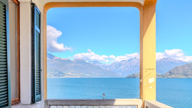 Un balcón con vista a un lago y montañas.