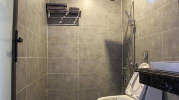 A modern bathroom with a shower, toilet, and a towel rack.