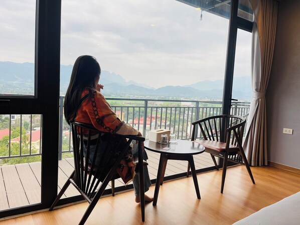 Una habitación con balcón con vistas a un paisaje montañoso.