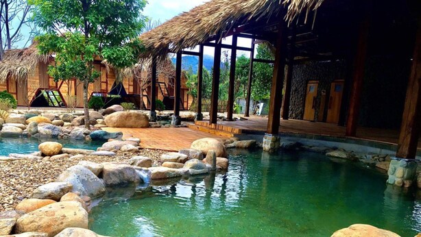 A tranquil outdoor pool area with large rocks and a wooden structure. - Dragonfly Hotel Nghia Lo - Free Sauna & Onsen (Nghia Lo)